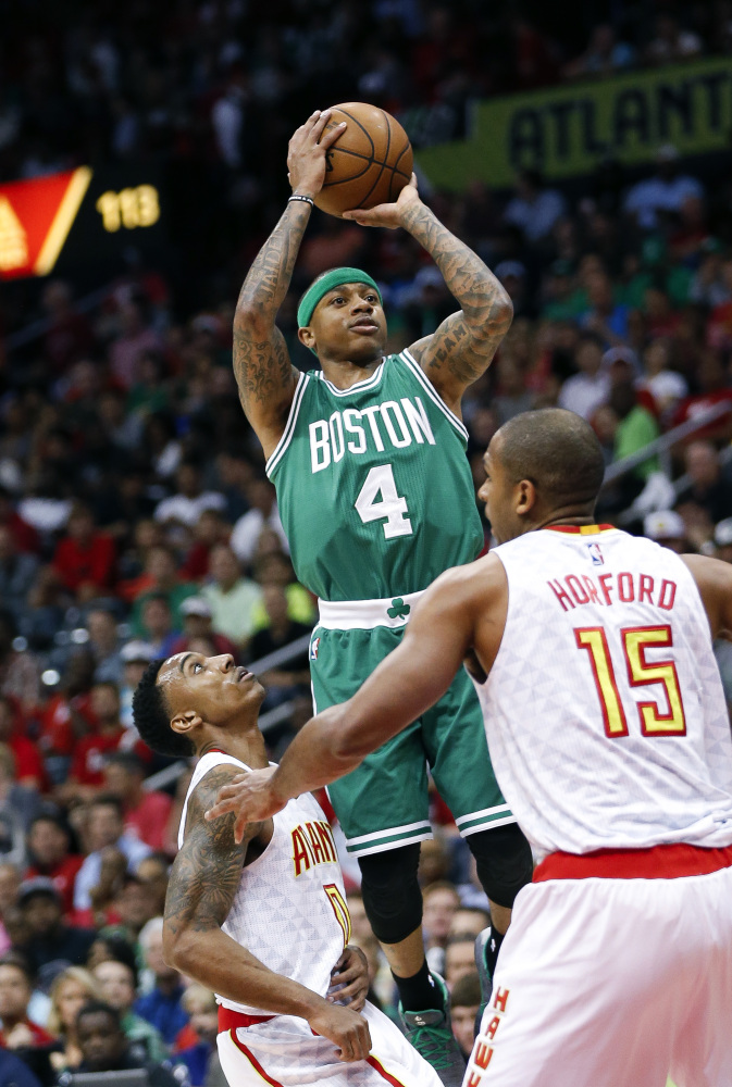 Boston guard Isaiah Thomas shoots against Hawks guard Jeff Teague (0) and center Al Horford (15) during the first half.