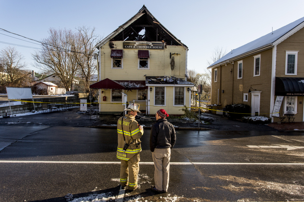 Deputy Fire Chief Eric Sylvain speaks with Hugh Wade of Freeport, a co-owner of the building that housed the Corsican restaurant.