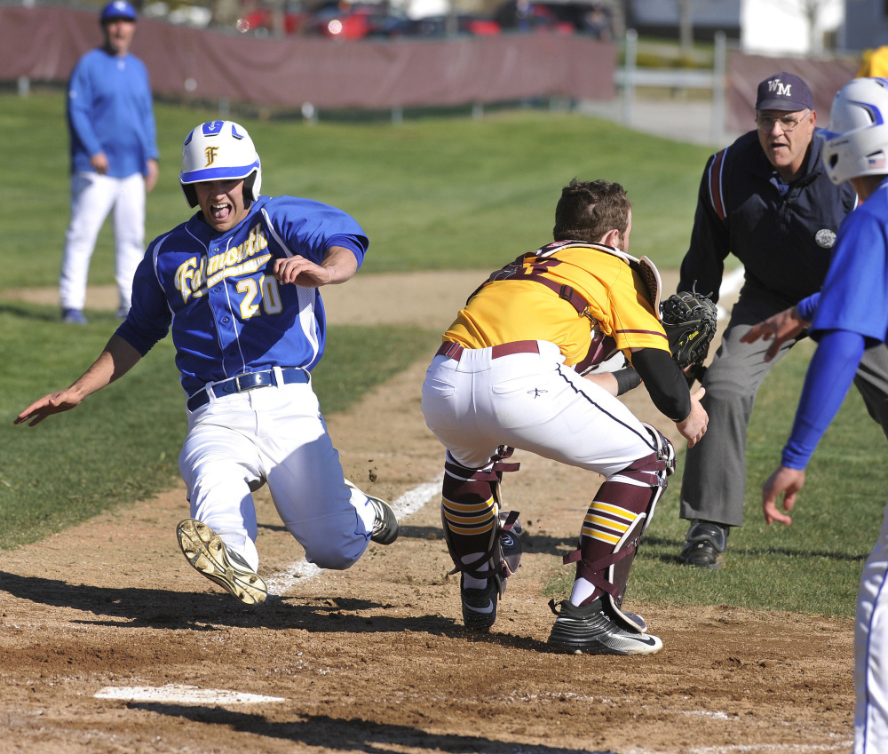 Connor Aube, who scored three runs for Falmouth, slides across the plate in the second inning Wednesday as Cape Elizabeth catcher Brendan Tinsman awaits the throw.