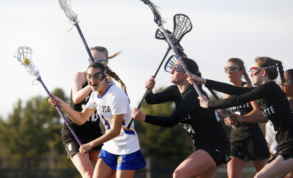 Olivia Stucker of Falmouth draws a crowd of Waynflete defenders during their girls' lacrosse game Thursday. Among the defenders are Lydia Giguere, left; Ali Pope, center; and Clair Dubois, second from right. Falmouth came away with a 17-6 victory.