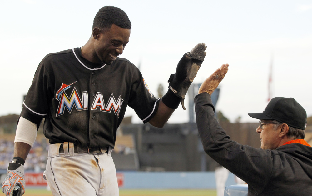 Miami Marlins' Dee Gordon, left, gets congratulations from manager Don Mattingly after scoring Wednesday. Gordon says he unknowingly took the performance-enhancing drugs that led to his 80-game suspension, but he'll accept the penalty.
