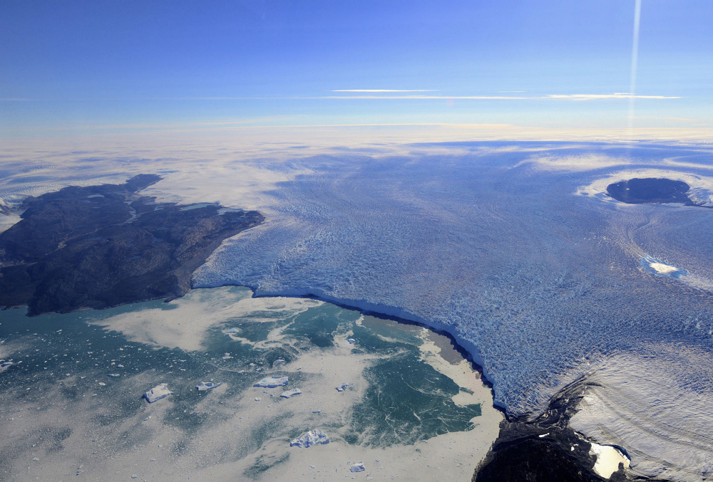 A West Greenland glacier in this 2014 image shows sediment plumes of surface meltwater that snakes its way beneath the ice sheet, gathering eroded material and then floating to the top, sucking warm salt water back in as it enters the ocean.