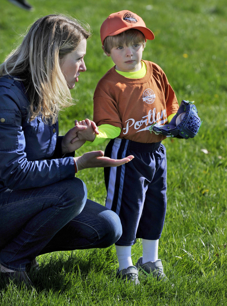 Erin Yarema tries to coax her son, 4-year-old Nicholas Yerema, to go play with teammates as they were getting ready for the Little League Opening Day ceremonies Saturday. Yarema plays for Deering Memorial Post 6859. 