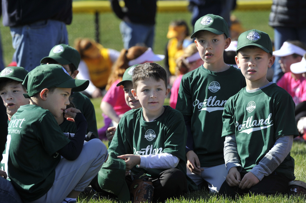 From left, cPort Credit Union Little Leaguers Jack O'Connell, 8, Jaxon Roberts, 7, Rowen Reed, 6, and Quinn Derrig, 7, sit with their team during Little League Opening Day ceremonies Saturday in Portland.