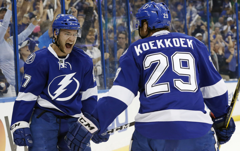 Tampa Bay left wing Jonathan Drouin, left, celebrates with defenseman Slater Koekkoek after Drouin's goal gave the Lightning a two-goal lead in the first period of their 4-1 win over the New York Islanders on Saturday in Tampa, Florida.