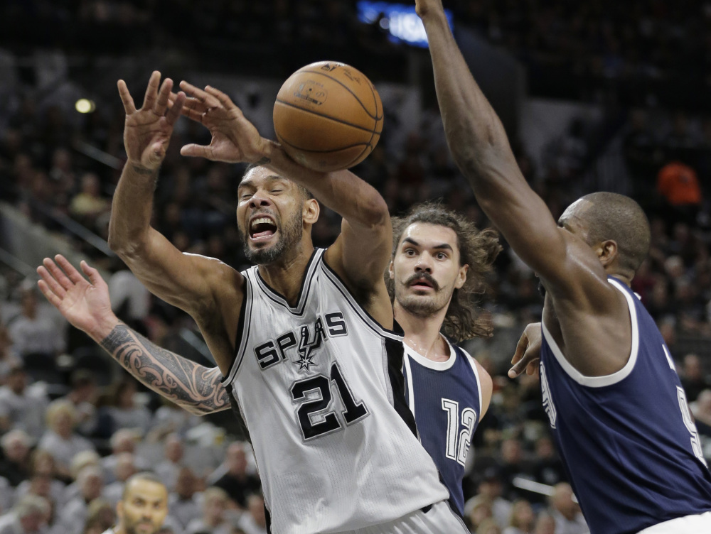 San Antonio Spurs forward Tim Duncan (21) is fouled by Oklahoma City Thunder forward Serge Ibaka, right, as he tries to score during the second half  Saturday in San Antonio. (AP Photo/Eric Gay)