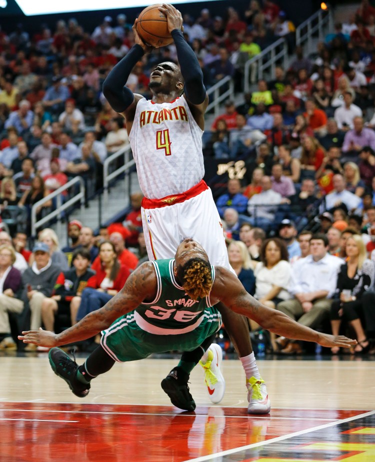 Atlanta's Paul Millsap knocks over Boston's Marcus Smart as he shoots during the Hawks' Game 2 win Tuesday night.   The Associated Press