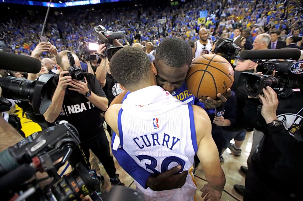 Golden State Warriors' Stephen Curry is hugged by teammate Draymond Green after the team's record-breaking 125-104 win over the Memphis Grizzlies Wednesday. The Associated Press