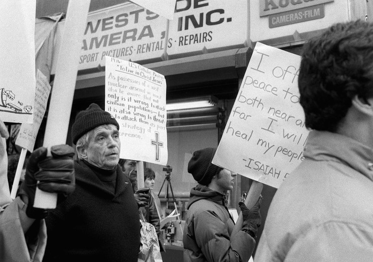 Daniel Berrigan marches with about 40 others outside of the Riverside Research Center in New York on April 9, 1982, calling for peace and a reduction in nuclear arms. Berrigan was among 15 protesters arrested after crossing police lines and throwing lamb’s blood at the officers. The pacifist priest has died at 94.