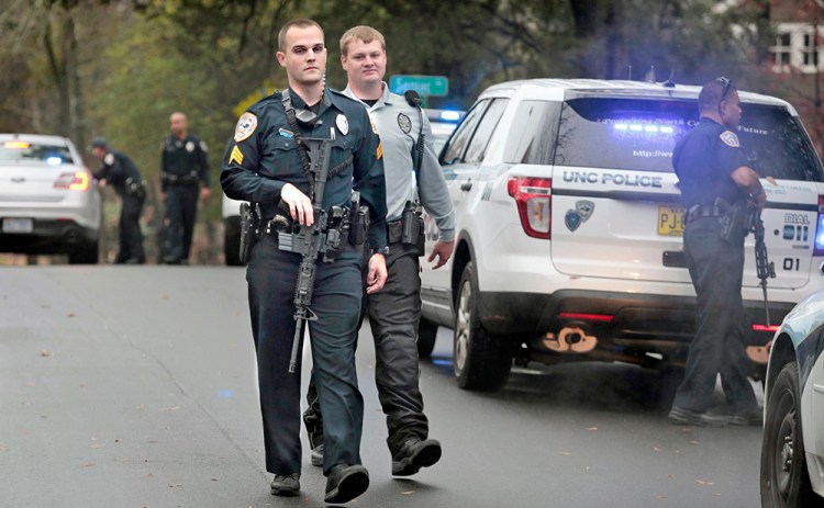 University of North Carolina police officers return to their patrol cars after responding to a report of a man with a rifle near the school's campus in Chapel Hill, N.C., in this Dec. 2, 2015, photo,  Harry Lynch/The News & Observer via AP