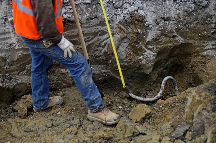 A lead main service line is dug up and measured as contractors replace residential water lines recently in Flint, Mich. Rachel Woolf/The Flint Journal-MLive.com via AP