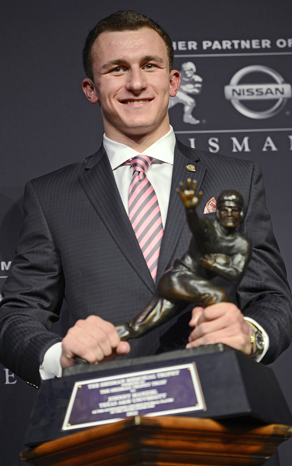 Then-Texas A&M quarterback Johnny Manziel poses with the Heisman Trophy after becoming the first freshman to win the college football award, in this Dec. 8, 2012, photo. Manziel was indicted by a grand jury Tuesday on misdemeanor charges stemming from a domestic violence complaint by his ex-girlfriend. The Associated Press