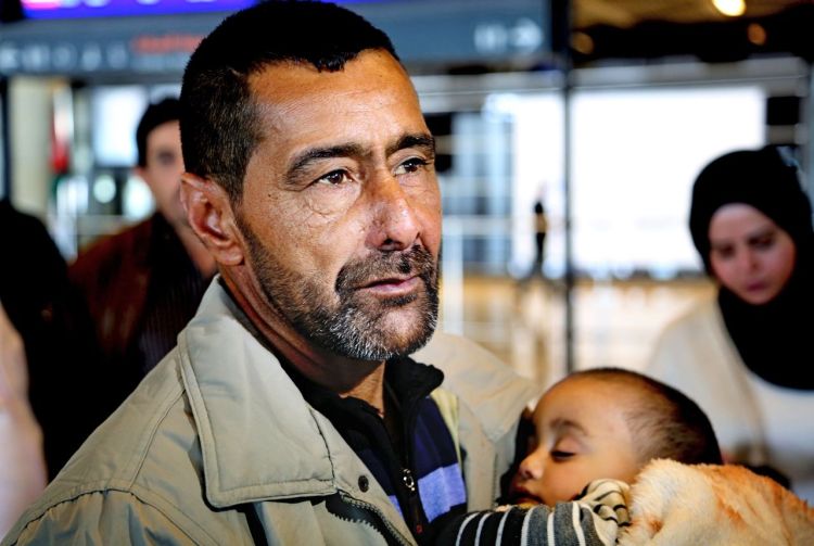 Refugee Ahmad al-Abboud waits with his family at the International Airport of Amman, Jordan, Wednesday. Al-Abboud, who is being resettled with his wife and five children, said he is thankful to Jordan – where he has lived for three years after fleeing Syria's civil war – but he is hopeful of finding a better life in the U.S. The Associated Press