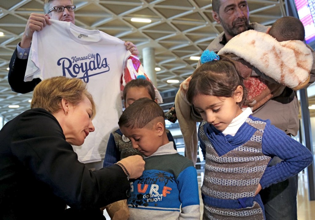 U.S. Ambassador to Jordan Alice Wells meets with Syrian refugee Ahmad al-Abboud, top right, and his family at the International Airport of Amman, Jordan, Wednesday. The Associated Press