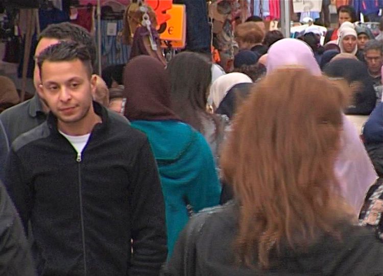 This image taken from an August 2014 video shows Salah Abdeslam, the fugitive from the Nov. 13 Paris attacks, strolling casually through the Molenbeek market. Like many of the men in the Islamic State cell blamed for the pair of deadly attacks, Abdeslam is a native of the Brussels neighborhood. TVbrussels via AP
