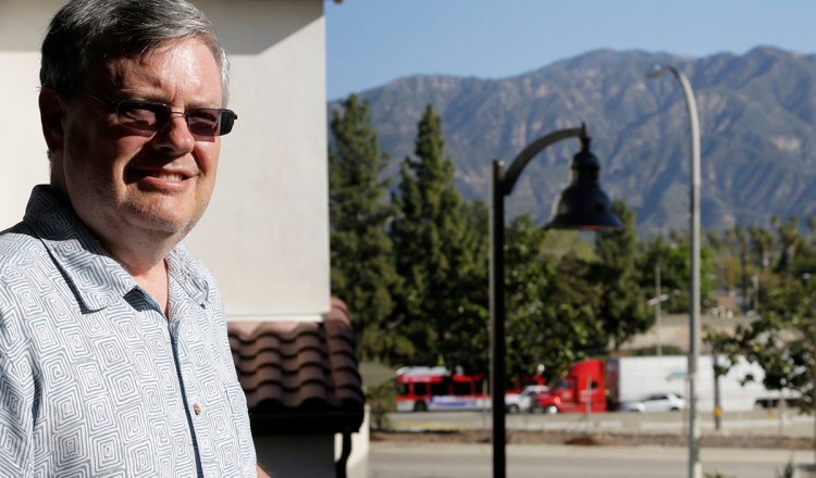 Robert Leviton stands on the balcony of his two-bedroom,  $666,000 townhouse in Pasadena, Calif. The highway traffic that runs alongside his complex creates a persistent din and is visible from all of his windows. The Associated Press