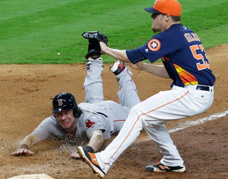 Boston Red Sox's Ryan Hanigan slides into home to score from third base on a wild pitch by Houston Astros' Ken Giles (53) in the 12th inning of a baseball game in Houston. Boston won 8-5.  The Associated Press