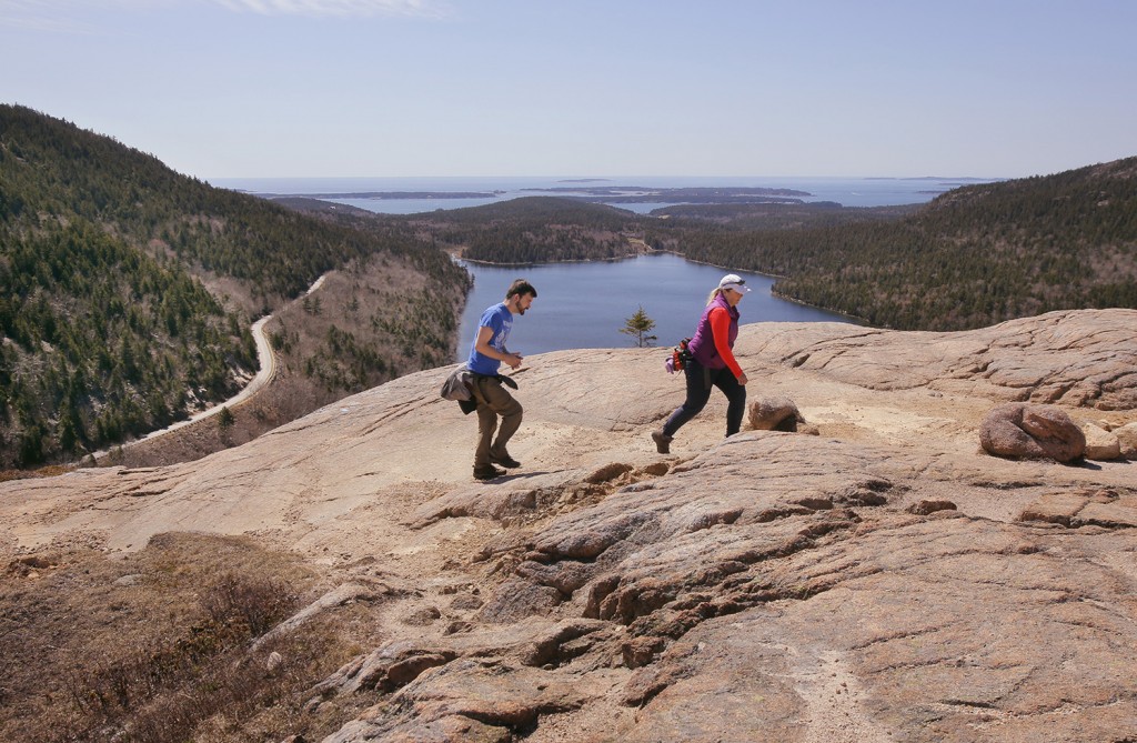 Ryan Reynolds of Hacock, left, and Florence Dunbar of Southwest Harbor hike over the summit of South Bubble in Acadia National Park on April 30. Gregory Rec/Staff Photographer