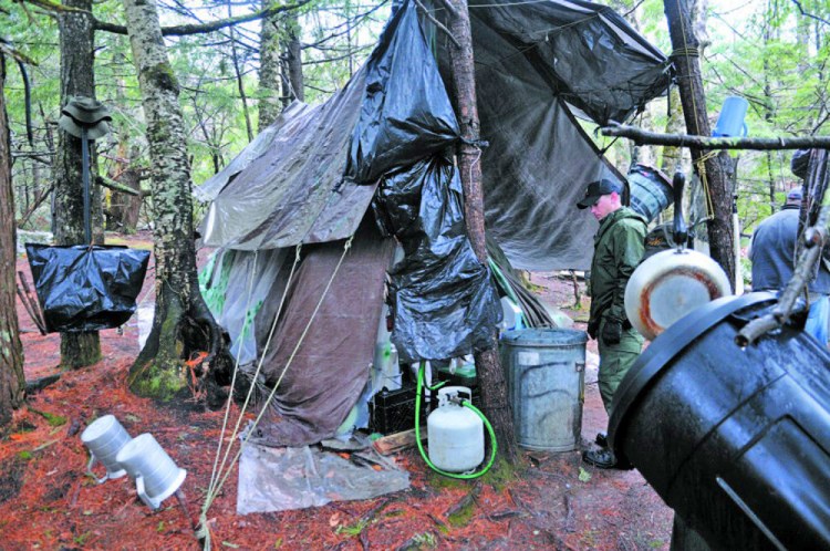 District Game Warden Aaron Cross inspects Christopher Knight's camp in a remote, wooded section of Rome in this 2013 file photo. 