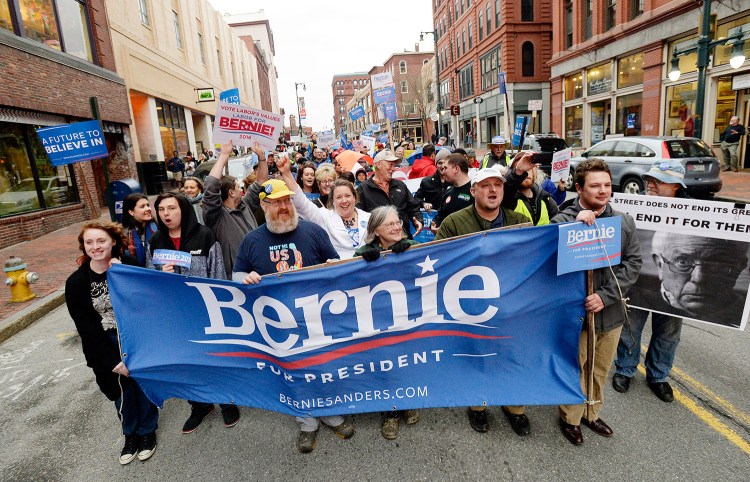 Bernie Sanders supporters march down Congress Street in Portland on Thursday evening, a day before the state Democratic Party Convention.
