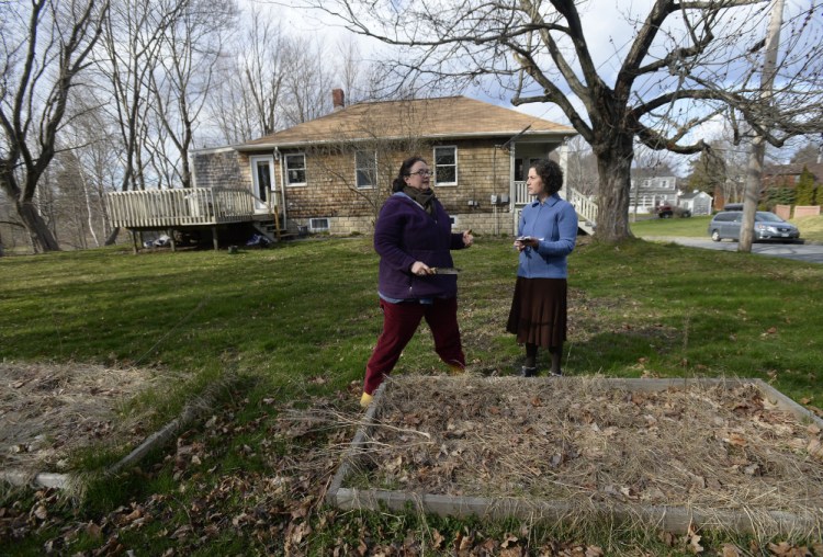 Lisa Fernandes, founder and executive director of The Resilience Hub, consults with new gardener Peggy Grodinsky.