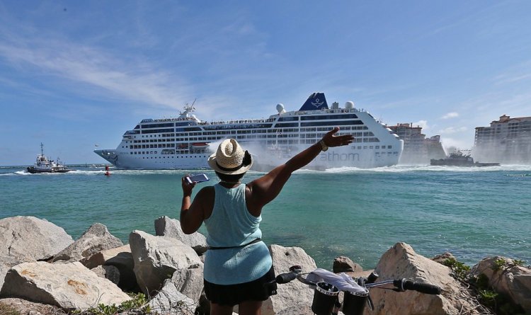 A woman from Cuba waves Adonia leaves port in Miam en route to Cuba.