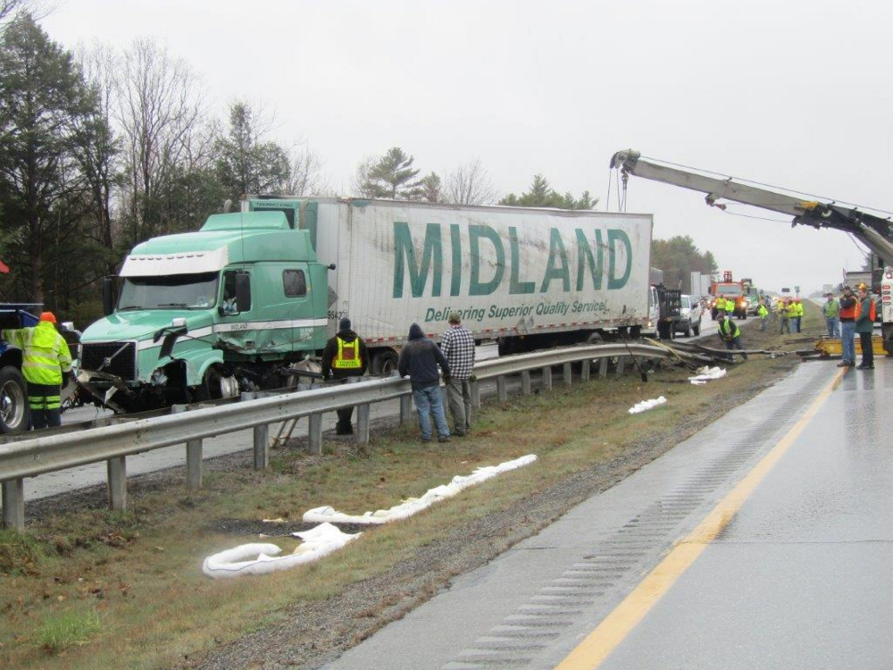 Crews work to clear the scene following a tractor-trailer accident early Monday morning on the Maine Turnpike in Farmingdale.