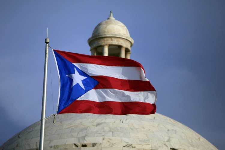 In this Wednesday, July 29, file 2015 photo, the Puerto Rican flag flies in front of Puerto Rico's Capitol as in San Juan, Puerto Rico.