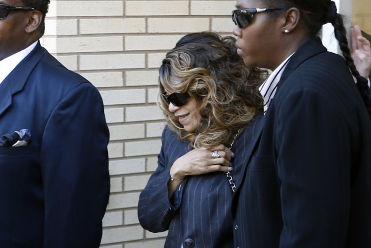 Tyka Nelson, center, the sister of Prince, is escorted by unidentified people as she leaves the Carver County Courthouse Monday in Chaska, Minn. where a judge has confirmed the appointment of a special administrator to oversee the settlement of Prince's estate.