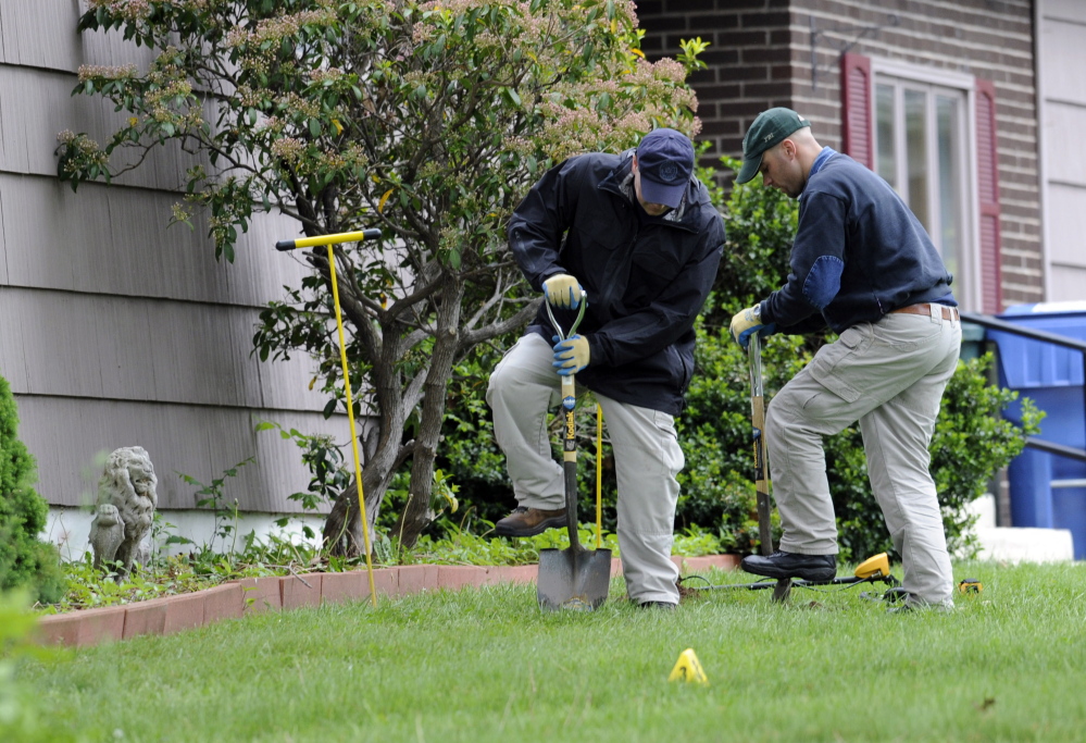 Law enforcement agents dig in the front yard of the home of Robert Gentile in Manchester, Conn., during a previous visit. Agents returned to the house Monday.