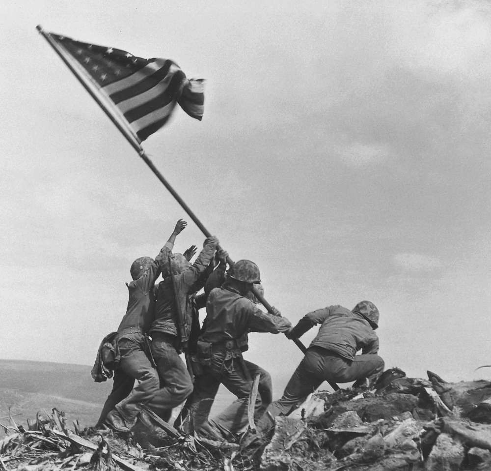 U.S. Marines of the 28th Regiment, 5th Division, raise the American flag atop Mount Suribachi on Iwo Jima in this famous photo taken on Feb 23, 1945.
