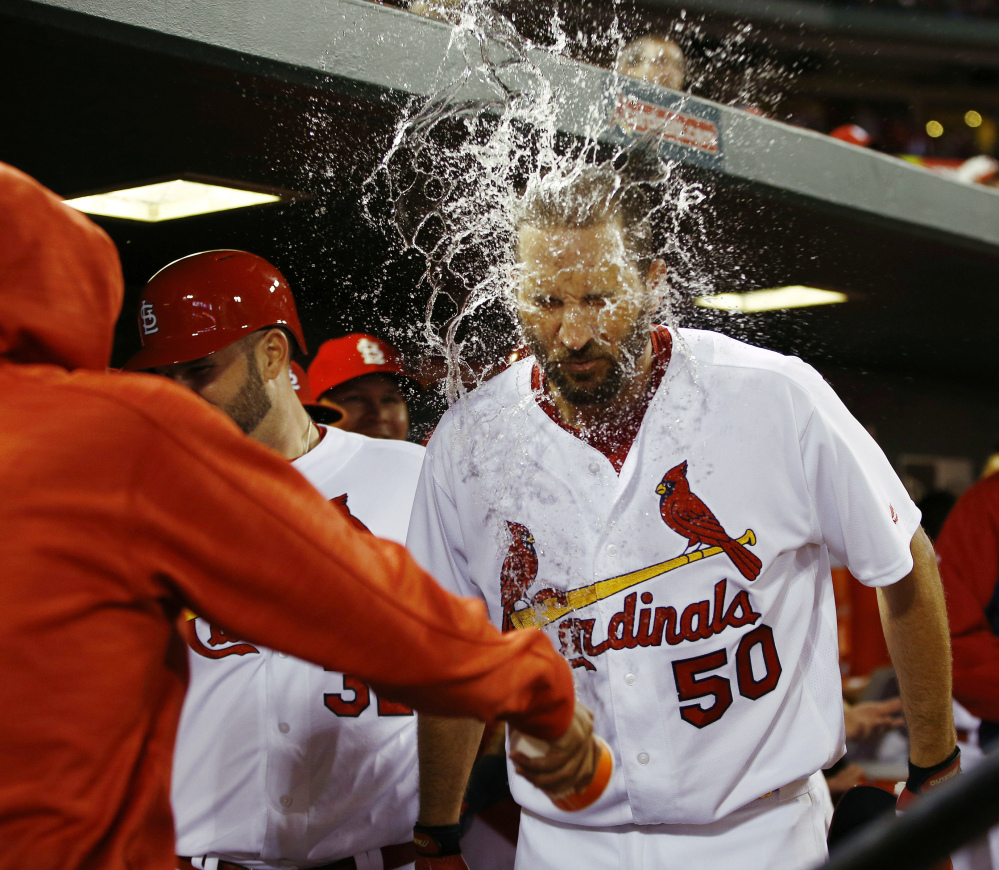 Adam Wainwright of the St. Louis Cardinals is splashed with water by a teammate after hitting a three-run homer during a 10-3 win at Philadelphia on Monday. Wainwright also pitched six strong innings as the Cardinals broke a four-game losing streak.