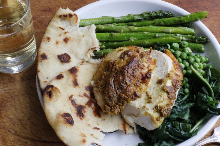 Tandoori roast chicken is made tender with a marinade of yogurt and lemon juice that is seasoned with earthy cumin, garam masala, ginger and garlic.   The Associated Press
