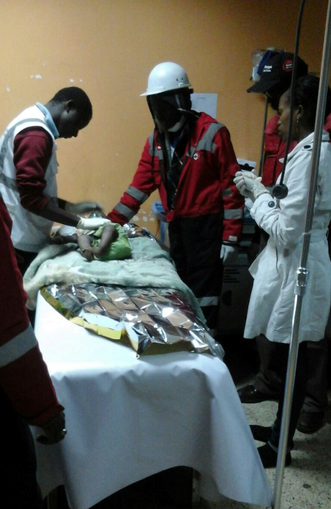 Kenya Red Cross paramedics in Nairobi on Tuesday attend to a baby girl rescued from the rubble of a six-story building that collapsed after days of heavy rain.