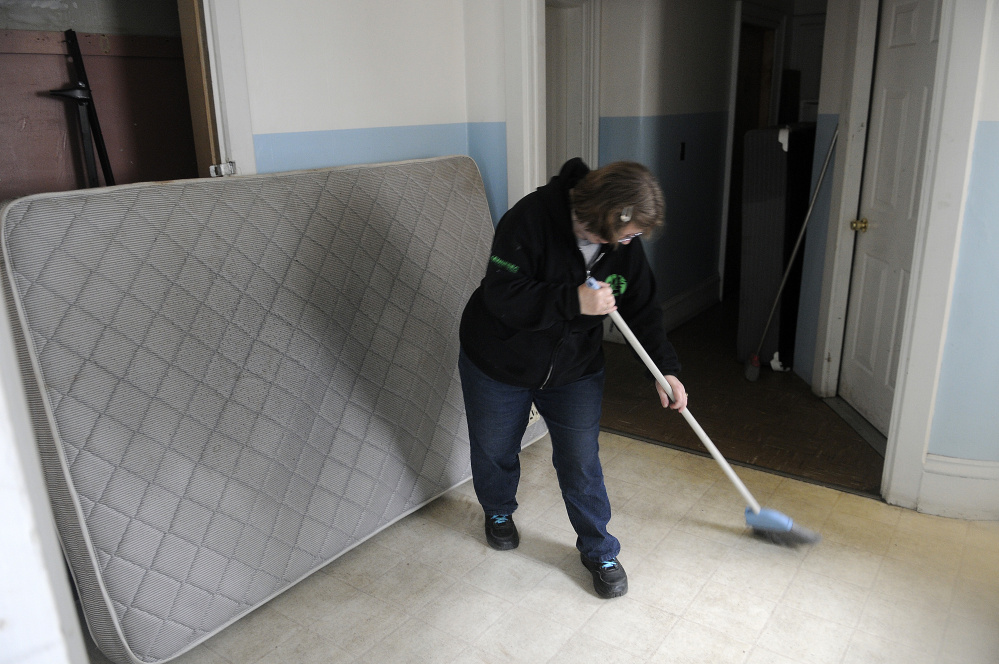 Andrea Anderson cleans the kitchenette and bathroom area Tuesday at 382 Water St. in Augusta.