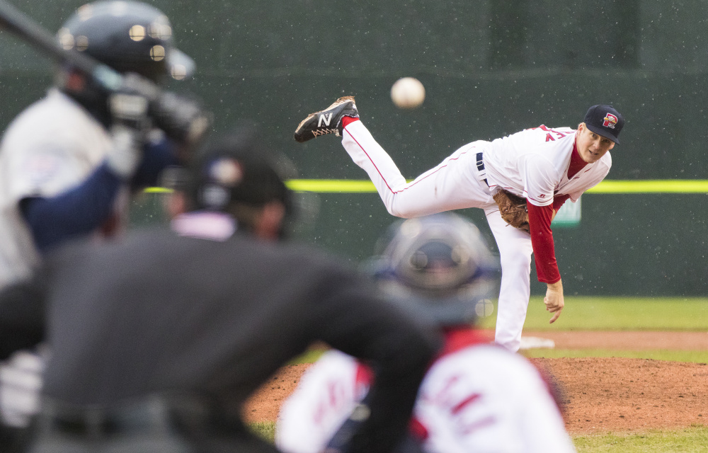Cold rain falls on Hadlock Field as Sea Dogs pitcher Ty Buttrey throws a pitch against the Binghamton Mets on Wednesday night.