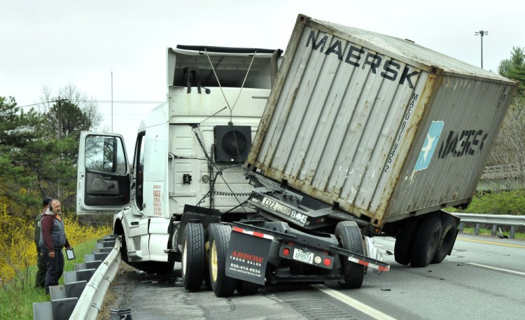 Driver Paul Cusano surveys the scene after his tractor-trailer jackknifed in the northbound lanes of the Interstate 95 overpass near Kennedy Memorial Drive in Waterville on Thursday.