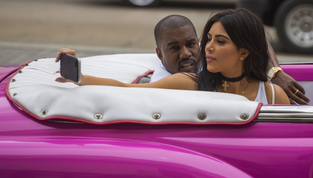 American reality-show star Kim Kardashian takes a selfie as she rides in a classic car next to her husband, rapper Kayne West, in Havana on Wednesday.