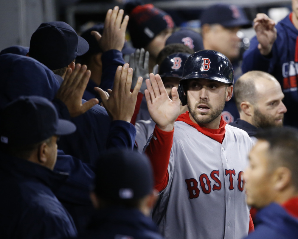 Boston Red Sox's Travis Shaw celebrates in the dugout after scoring on a sacrifice fly by Brock Holt during the third inning of a baseball game against the Chicago White Sox on Thursday, in Chicago.