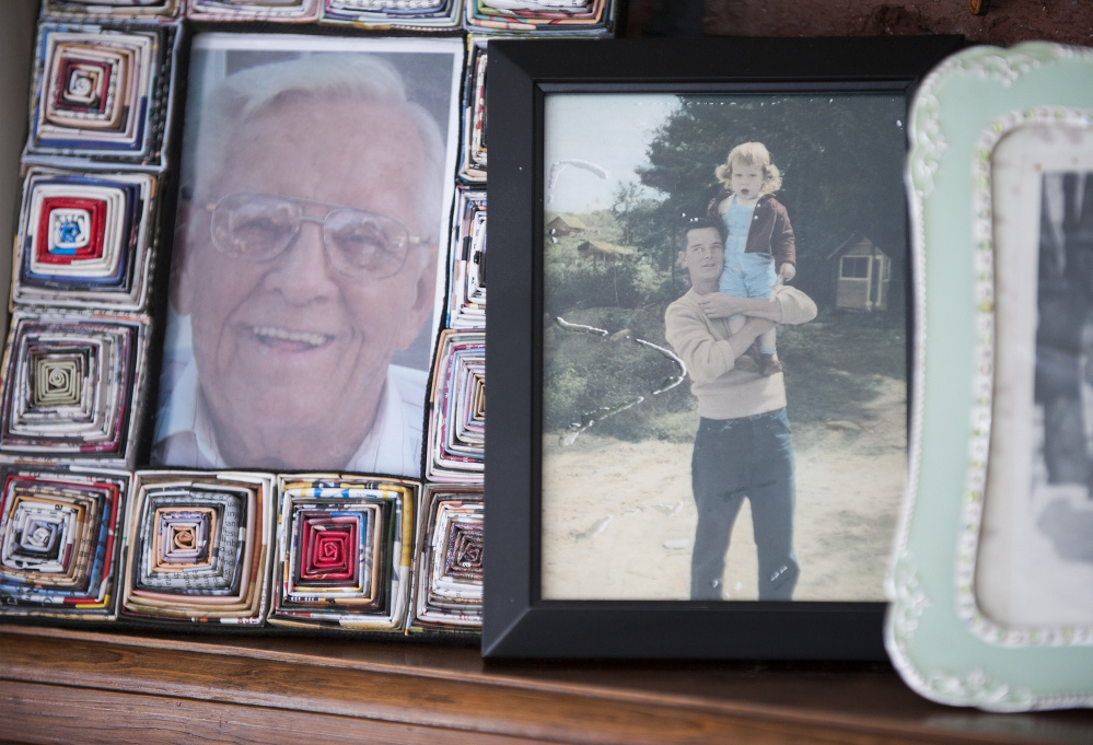 Pictures of John P. McCleary Sr., including one of him holding his daughter Kathy Day, line the mantel of Day’s home in Bangor. Day has ben crusading to save lives ever since her father died of a preventable hospital-acquired infection in 2009.