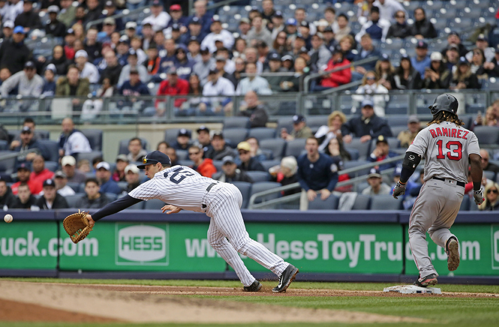 Yankees first baseman Mark Teixeira dives for a ball thrown by third baseman Chase Headley for an error as the Red Sox's Hanley Ramirez is safe at first base during the fourth inning of Saturday's game in New York. Ramirez advanced to second base on the play.