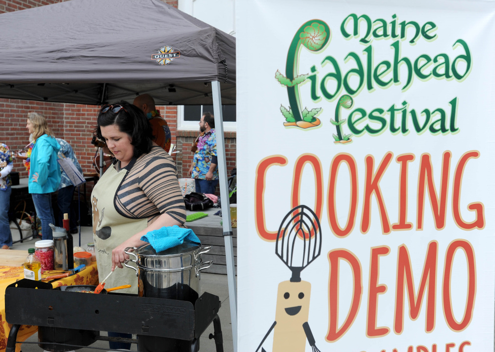 Ashley Montgomery prepares a dish of lobster mushrooms and fiddleheads over linguini Saturday at the fifth annual Maine Fiddlehead Festival in Farmington.