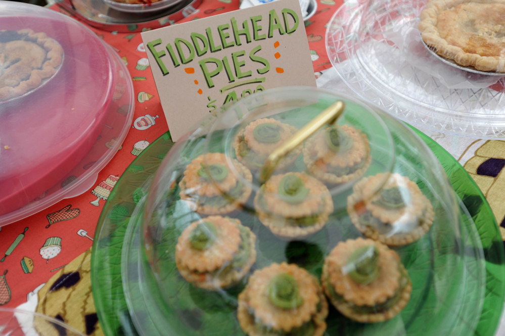 A batch of fiddlehead pies created by Marjorie Cormier, owner of My Pie, awaits a buyer Saturday.