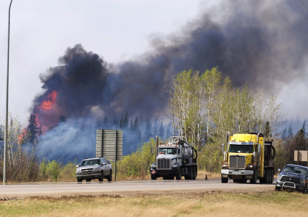 Flames flare up from hot spots along the highway to Fort McMurray in Alberta on Sunday.
Ryan Remiorz/The Canadian Press via AP
