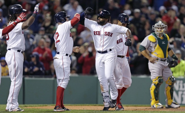 Jackie Bradley Jr. celebrates after his grand slam in the sixth inning of Monday night's game. The home run broke the game open and Bradley extended his hitting streak to 15 games.