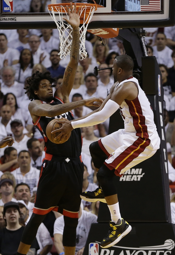Dwyane Wade of the Miami Heat finds his way to the basket closed off by Lucas Nogueira of the Toronto Raptors during the first half Monday night. Wade carried Miami down the stretch for a 94-87 overtime victory.