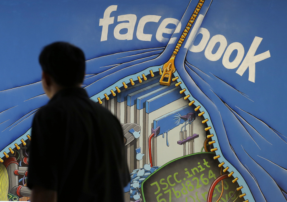 A man walks past a mural in an office on the Facebook campus in Menlo Park, Calif. On Thursday, the company released details of how items are chosen for its Trending Topics feature and says it has a system of checks and balances to prevent bias.
