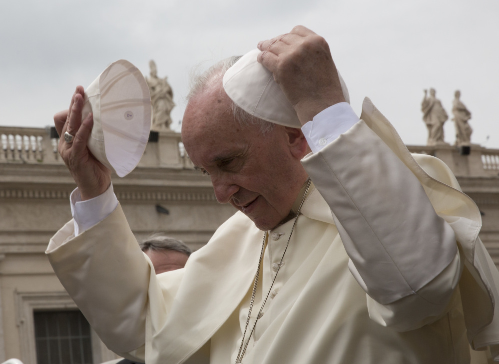 Pope Francis  replaces one cap with another given to him by a worshiper after his weekly audience in St. Peter's Square. The pope reaffirmed women's lack of influence in church decisions.