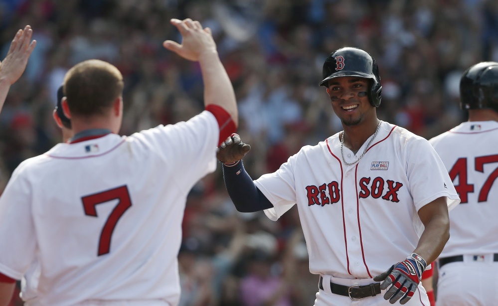 Xander Bogaerts, right, celebrates after scoring the tying run on a triple by David Ortiz during the ninth inning against the Houston Astros in Boston on Saturday. (AP Photo/Michael Dwyer)