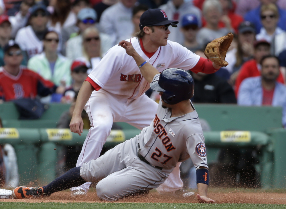 Houston's Jose Altuve slides safely into third base as Boston's Josh Rutledge, top, waits for the ball in the fifth inning.